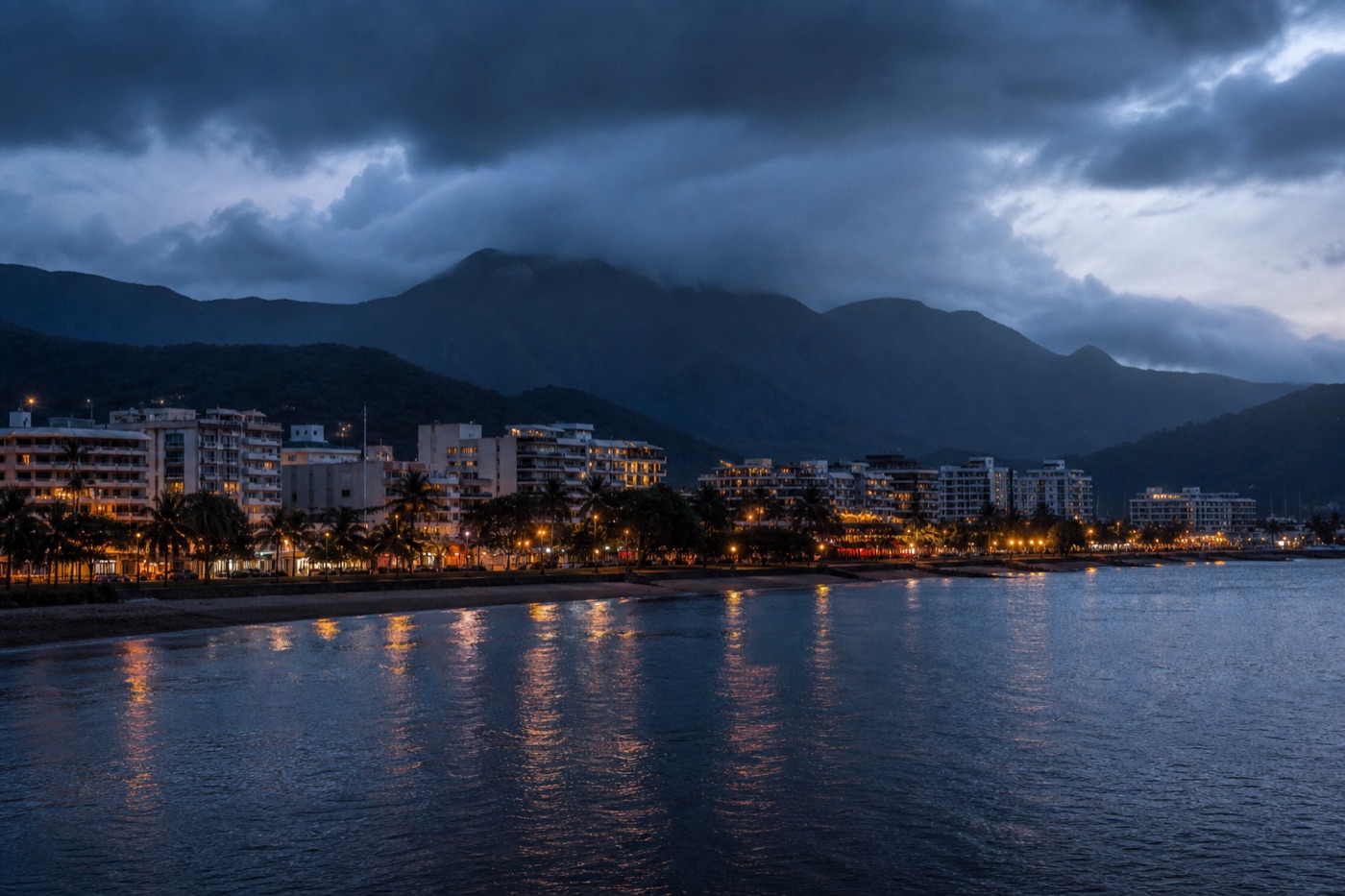 The regional tropical city of Cairns at dusk, low-rise buildings against distant rainforest mountains